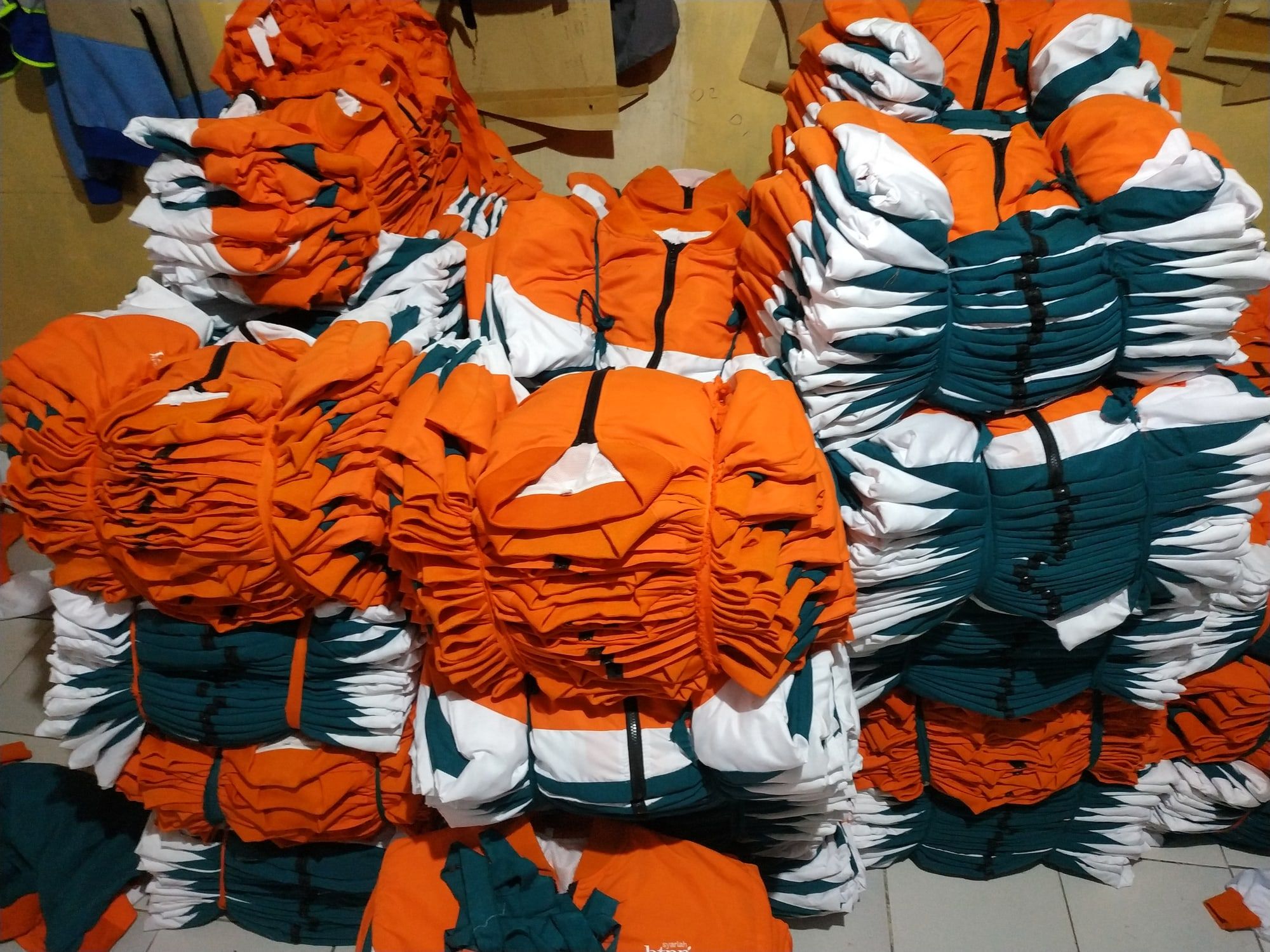 Tumpukan jaket tiga warna yang telah selesai dijahit